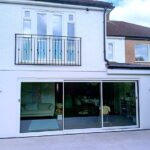 rear house extension with sliding glass doors and patio Amersham