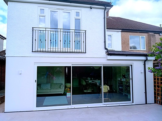 rear house extension with sliding glass doors and patio Amersham